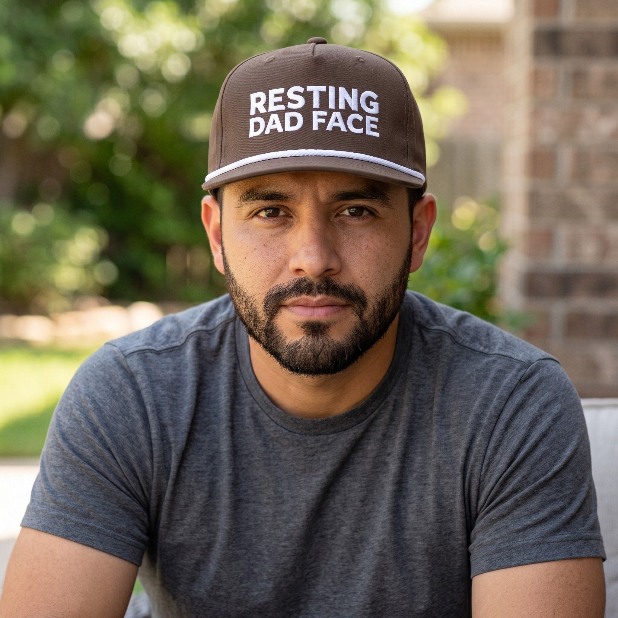 Image of a man wearing an espresso cap with "Resting Dad Face" embroidery