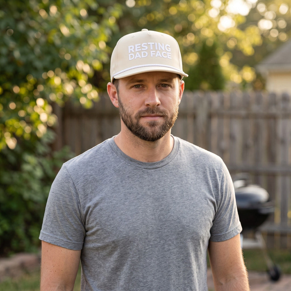 Image of a man wearing an ivory cap with "Resting Dad Face" embroidery